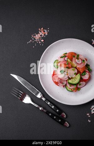 Köstlicher veganer Salat mit frischem Gemüse aus Tomaten, Gurken und Radieschen Stockfoto