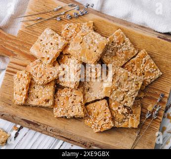 Mehrkörniges Getreide knusprige quadratische Riegel mit Kürbiskernen auf hölzernem Hintergrund Stockfoto