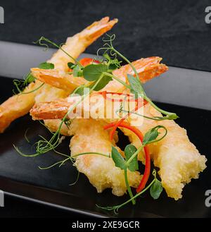 Gebratene Garnelen Tempura auf schwarzem Steinteller Stockfoto
