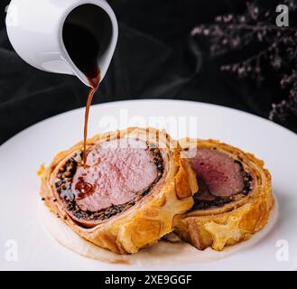 Filet wellington in Blätterteig auf Teller Stockfoto