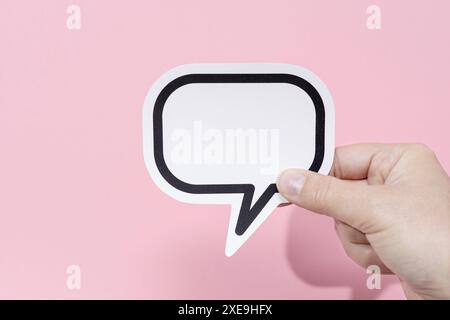 Hand hält eine leere Sprechblase isoliert auf rosa Hintergrund. Vorlagenmodell Stockfoto