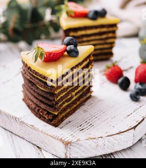 Köstlicher, frischer Schokoladenkuchen mit Beeren auf Holztisch Stockfoto