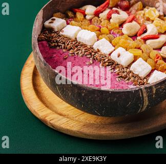 Gesunder Smoothie zum Frühstück mit Rosinen und Cashewkernen in Kokosnussschale Stockfoto