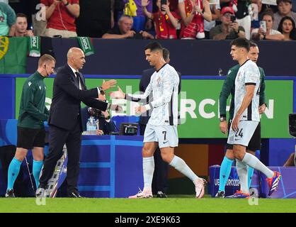 Der Portugieser Cristiano Ronaldo (Mitte) schüttelt Portugal-Trainer Roberto Martinez (links), als er beim Gruppenspiel der UEFA Euro 2024 in der Arena AufSchalke in Gelsenkirchen ersetzt wird. Bilddatum: Mittwoch, 26. Juni 2024. Stockfoto