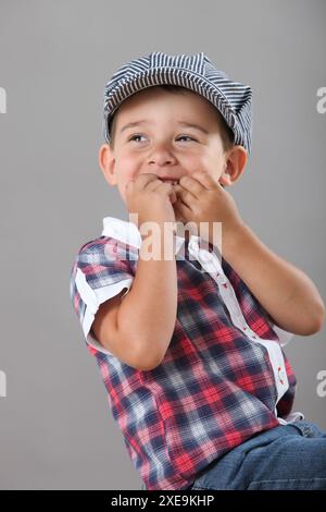 Porträt eines fröhlichen kleinen Jungen auf grauem Hintergrund Stockfoto