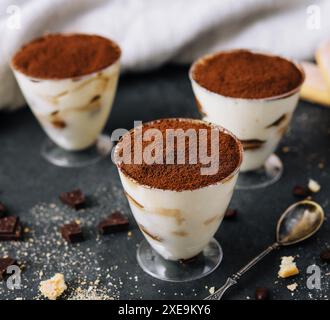 Italienisches Dessert Tiramisu im Glas und Eclairs mit Schokoladenscheiben Stockfoto