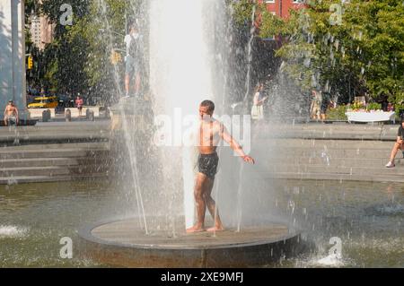 New York, Usa. Juni 2024. Während des heißen Sommerwetters in Manhattan, New York City, wird eine Person beim Spaziergang durch einen Brunnen im Washington Square Park beobachtet. Quelle: SOPA Images Limited/Alamy Live News Stockfoto