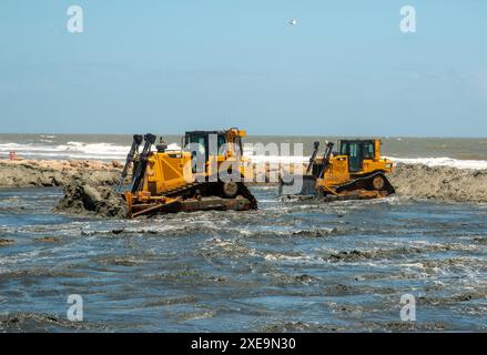 Bauunternehmer des U.S. Army Corps of Engineers im Bezirk Charleston platzieren Material während der Übergabe von Folly Beach am 20. Juni 2024 in Folly Beach, South Carolina. Die Folly Beach Renourishment ist ein Nutzungsprojekt, das drei Zwecken dient: Folly Beach für die Reduzierung von Schäden an Küstenstürmen zu erneuern, den Folly River-Schifffahrtskanal auszubaggern und Material auf dem Bird Key zu platzieren, um die Erosion des kritischen Vogellebensraums zu reduzieren. Das 18-Millionen-Dollar-Projekt wird vollständig vom Corps of Engineers finanziert und wird 1,3 Millionen Kubikyard Sand auf den Strand legen Stockfoto