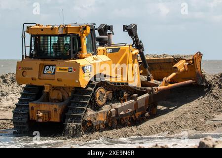 Bauunternehmer des U.S. Army Corps of Engineers im Bezirk Charleston platzieren Material während der Übergabe von Folly Beach am 20. Juni 2024 in Folly Beach, South Carolina. Die Folly Beach Renourishment ist ein Nutzungsprojekt, das drei Zwecken dient: Folly Beach für die Reduzierung von Schäden an Küstenstürmen zu erneuern, den Folly River-Schifffahrtskanal auszubaggern und Material auf dem Bird Key zu platzieren, um die Erosion des kritischen Vogellebensraums zu reduzieren. Das 18-Millionen-Dollar-Projekt wird vollständig vom Corps of Engineers finanziert und wird 1,3 Millionen Kubikyard Sand auf den Strand legen Stockfoto