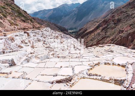 Terrassen von Salineras de Maras im heiligen Tal der inkas, umgeben von Vegetation an einem sonnigen Sommertag in peru Stockfoto