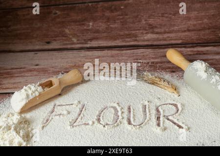 Mehl auf einem Holztisch gesiebt, auf dem das Wort Mehl steht Stockfoto
