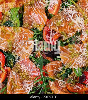 Köstliche heiße Pizza mit Lachs, Käse, Tomaten und Aradel Stockfoto