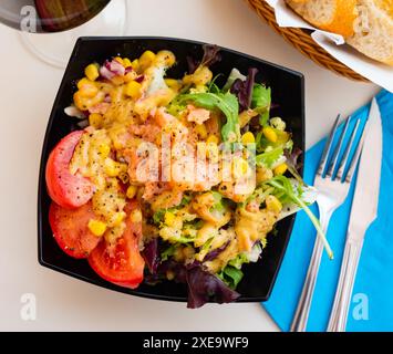 Salat mit geräuchertem Lachs, Tomaten, Mais, Grüns Stockfoto