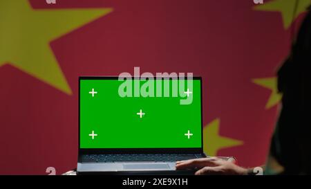 Chinesischer Soldat nutzt Militärtechnologie auf Green Screen Laptop, um Bedrohungen von Feinden zu identifizieren. Militärangehörige verwenden Software auf dem Modell-Notebook, um Informationen an die Front des Krieges zu übermitteln, Kamera A Stockfoto