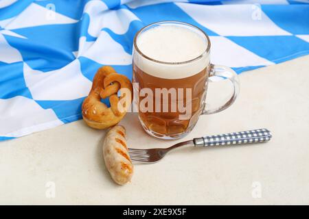 Becher mit Bier, leckerer Wurst, Brezel und Flagge Bayerns auf weißem Hintergrund. Oktoberfest Stockfoto