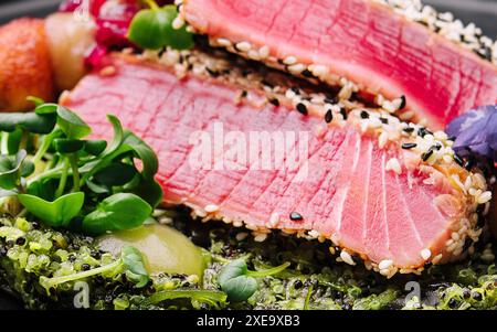 Seltene Ahi-Thunfisch-Steak-Scheiben mit frischen Kräutern Makro Stockfoto