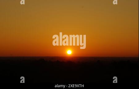 Während eines Sonnenaufgangs in Bagan übergeht die Sonne den Horizont Stockfoto