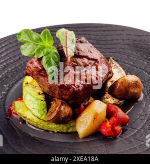 Schmackhaftes, geröstetes Rindfleischsteak mit Kartoffelscheiben und anderem Gemüse Stockfoto