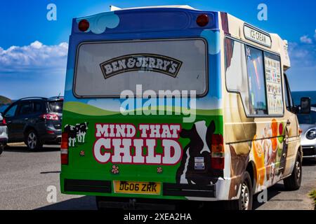 Farbenfroher Eiswagen, geparkt mit einem „Mind That Child“-Warnschild auf der Rückseite unter blauem Himmel Stockfoto