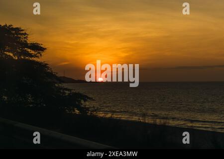 Sonnenuntergang mit rotem Himmel mit Wolken am Strand in Lateinamerika Stockfoto