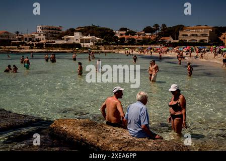 Urlauber kühlen sich am Strand von Punta Prima in Sant Lluis, Süd-Menorca, Balearen ab. Stockfoto