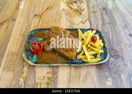 Schweinerippchen mit Pommes frites. Sie können die Kartoffeln einfach in Scheiben oder Stäbchen schneiden, sie in heißem Öl anbraten, bis sie goldbraun und knusprig sind, und mit Salz und spi würzen Stockfoto