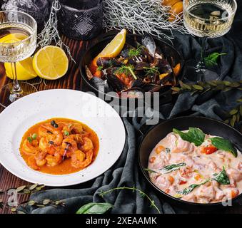 Lachs in Sahnesauce, Garnelen in Romesco-Sauce und Muscheln Stockfoto