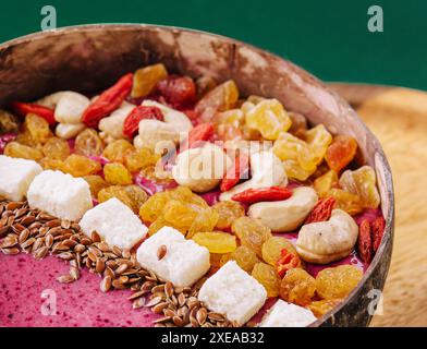 Gesunder Smoothie zum Frühstück mit Rosinen und Cashewkernen in Kokosnussschale Stockfoto