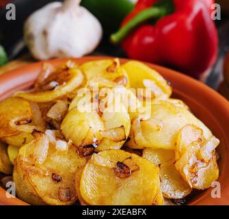 Gebratene Kartoffeln mit Zwiebeln auf Holztablett Stockfoto