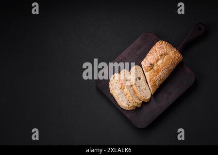 Knuspriges Weizenmehl-Baguette mit Sesamsamen auf einem hölzernen Schneidebrett Stockfoto