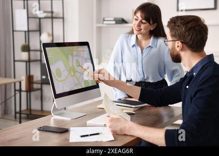 Kartografen arbeiten mit Katasterkarten am Computer am Tisch im Büro Stockfoto
