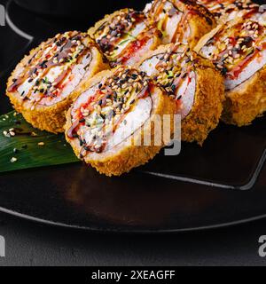 Warmes Sushi mit Ingwer und Wasabi auf einem schwarzen Steinteller serviert Stockfoto