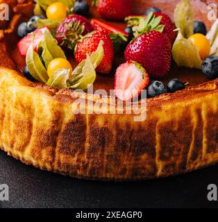 San Sebastian Käsekuchen mit Beeren auf schwarzem Teller Stockfoto