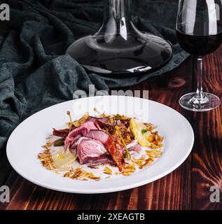 Italienisches Vitello Tonnato mit Flasche und Glas Wein Stockfoto