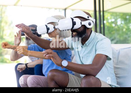 Zu Hause nutzen verschiedene Seniorengruppen VR-Headsets und genießen Virtual-Reality-Erlebnis Stockfoto