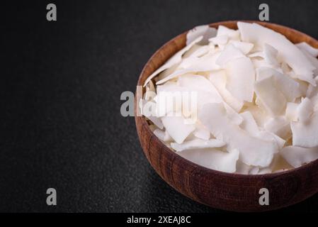 Weiße trockene Kokosflocken in einer Holzschale, die für die Zubereitung von Desserts vorbereitet ist Stockfoto