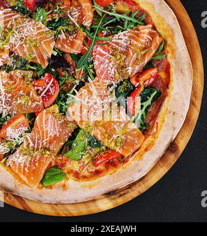 Köstliche heiße Pizza mit Lachs, Käse, Tomaten und Aradel Stockfoto