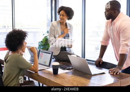 Besprechung des Projekts, afroamerikanisches Geschäftsteam, das Laptops und Diagramme im Büro verwendet Stockfoto