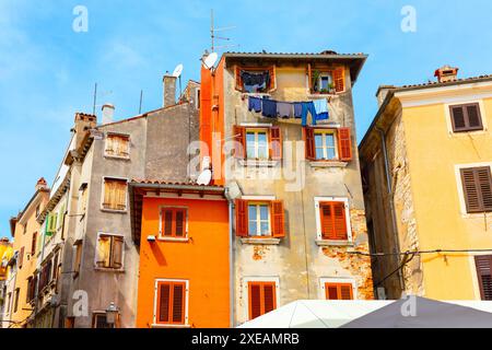 Farbenfrohe Häuser der Stadt Rovinj aus Kroatien. Reihe von Gebäuden mit orangefarbenen und gelben Fassaden. Architektur mit zahlreichen Fenstern Stockfoto
