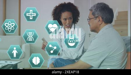 Bild medizinischer Ikonen über afroamerikanischer Ärztin mit Patient Stockfoto