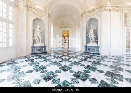 Venaria reale, Italien - Januar 2023: Luxuriöser Innenraum des alten Königspalastes. Galerieperspektive mit Fenster. Stockfoto