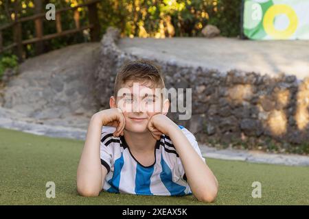 Junge, gekleidet als Sportler, der auf dem Gras posiert Stockfoto