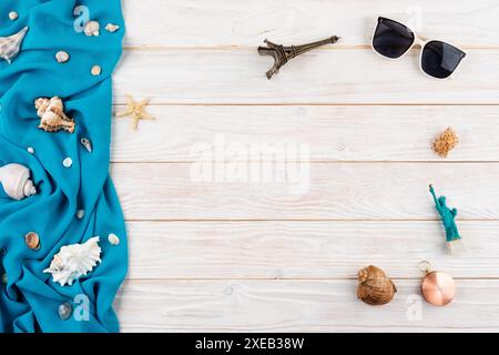 Muscheln, Sonnenbrillen, Kompass-Souvenirs, blauer Stoff und Seesterne auf weißen Planken Urlaubsplanung Stockfoto