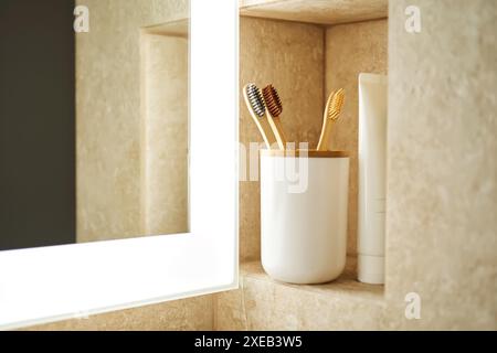 Natürliche Bambuszahnbürsten im Glas im Bad. Stockfoto