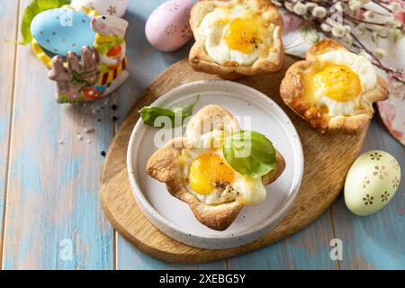 Rührei in Blätterteig mit Käse und Speck. Osterfrühstück auf einem festlichen Tisch. Stockfoto