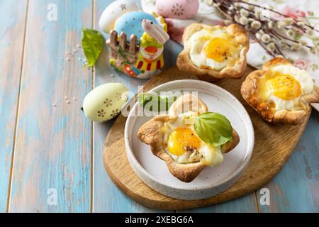 Rührei in Blätterteig mit Käse und Speck. Osterfrühstück auf einem festlichen Tisch. Kopierbereich. Stockfoto