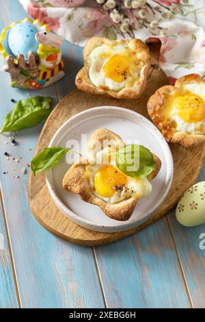 Rührei in Blätterteig mit Käse und Speck. Osterfrühstück auf einem festlichen Tisch. Kopierbereich. Stockfoto