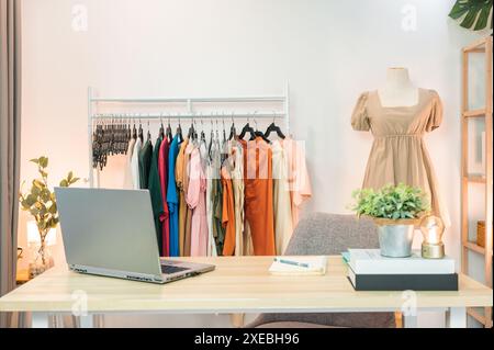Online-Bekleidungsgeschäft mit Laptop, Notebook, Kleiderständer, Schaufensterpuppe und Objektdekoration auf dem Schreibtisch im Heimbüro. Kleine Unternehmen, zu Hause arbeiten Stockfoto