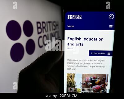 Person, die ein Handy hält, mit Webseite der Kultur- und Bildungsorganisation British Council vor dem Logo. Konzentrieren Sie sich auf die Mitte des Telefondisplays. Stockfoto