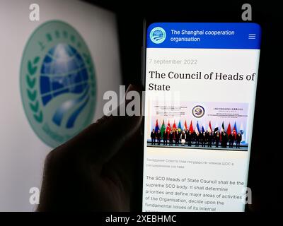 Person, die ein Smartphone hält, mit der Webseite der Eurasischen Shanghai Cooperation Organisation (SCO) vor dem Logo. Konzentrieren Sie sich auf die Mitte des Telefondisplays. Stockfoto